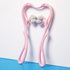 Pink handheld roller massager with ribbed rollers, plastic material, ergonomic design