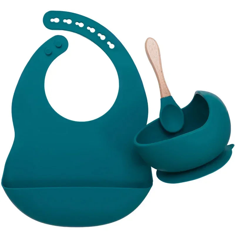 Teal silicone bib with adjustable fit, matching suction bowl, and wooden-handled spoon