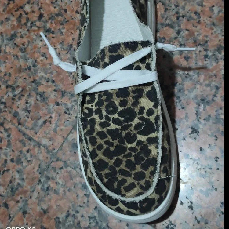 Leopard print canvas sneaker with white laces and rubber sole on tiled floor