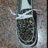 Leopard print canvas sneaker with white laces and rubber sole on tiled floor