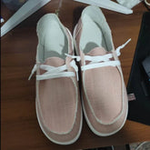 Light pink canvas slip-on shoes with white laces and stitching, casual fit