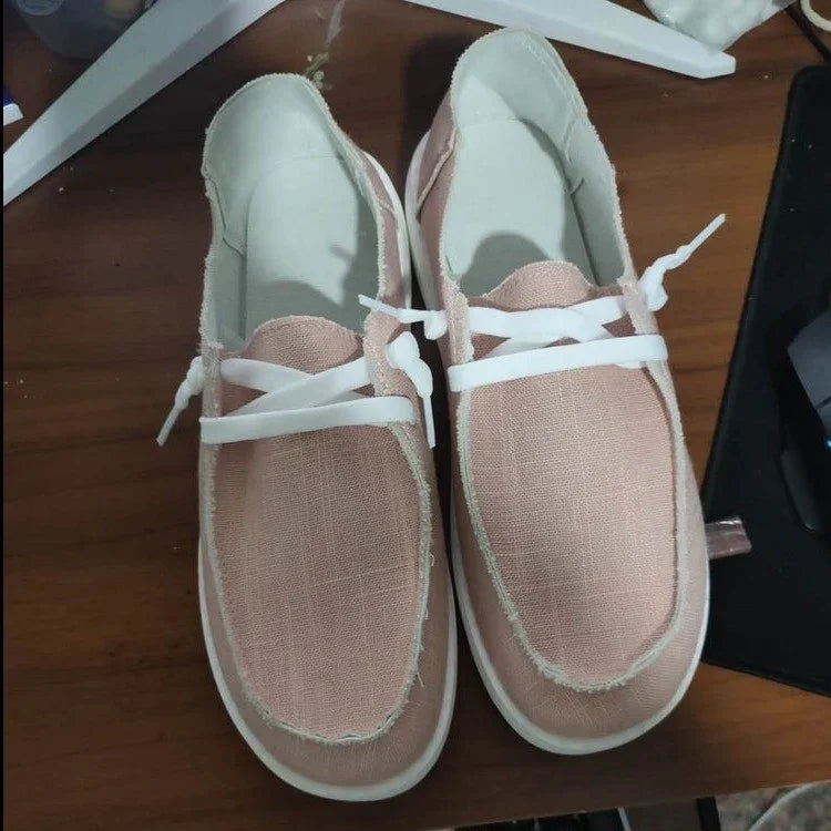 Light pink canvas slip-on shoes with white laces and stitching, casual fit