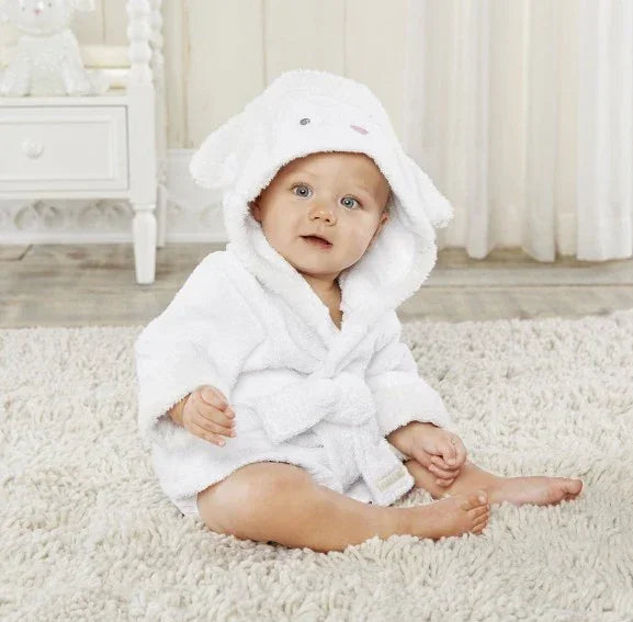 Baby in soft white hooded bathrobe with animal ears, sitting on plush carpet