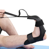 Black adjustable foot and ankle stretching strap with secure velcro fit, shown in use