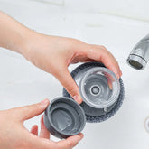 Hands cleaning a transparent plastic water bottle with a gray silicone cover in a sink
