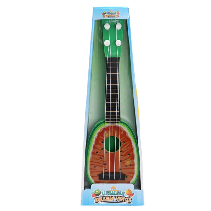 Green and red watermelon-shaped ukulele toy in packaging, four white tuning pegs