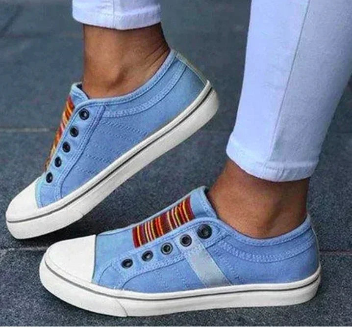 Light blue slip-on canvas sneakers with striped elastic bands, casual fit
