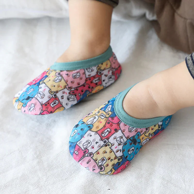 Colorful cartoon animal print toddler slippers with teal trim, soft fabric, snug fit