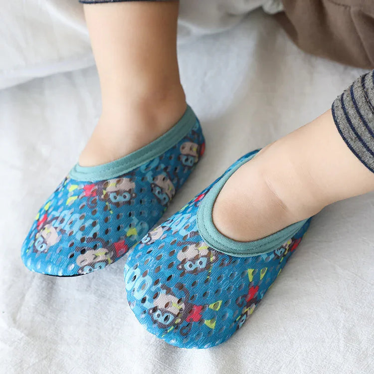 Baby feet in blue mesh slip-on socks with cartoon animal print, soft snug fit