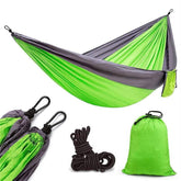 Lightweight green and gray nylon hammock with black carabiners, ropes, and matching carry bag