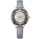 Elegant wristwatch with gold case, mother-of-pearl dial, gray leather strap, minimalist style