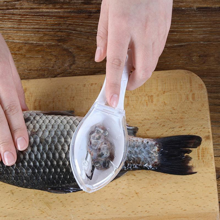 Hand using clear plastic fish scaler tool to remove scales from fish on cutting board