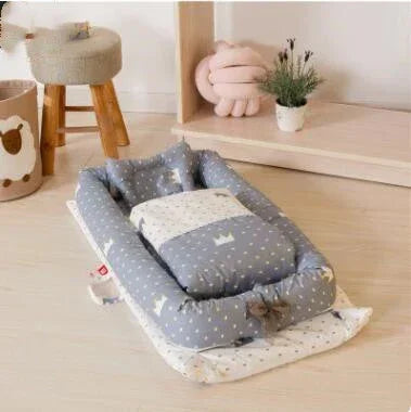 Soft gray and white cotton baby nest with crown pattern, cozy padded fit, modern nursery décor