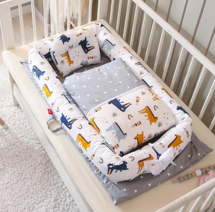 Soft baby nest with colorful animal print, gray bedding, and plush fit in crib setting.