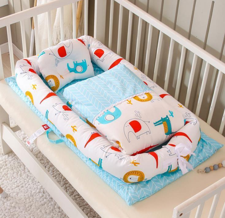 Soft baby nest with colorful animal print, light blue bedding, and cushioned sides in a crib