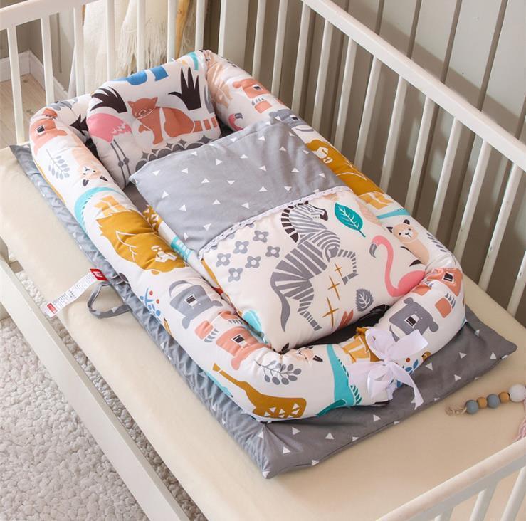 Colorful animal print baby nest with soft padded sides in crib, grey and white bedding, cozy fit
