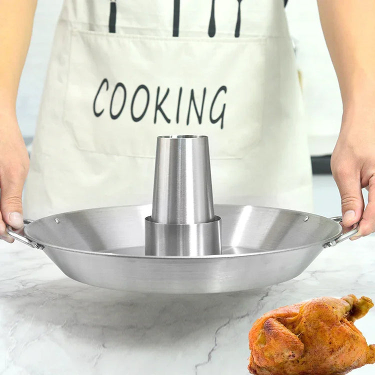 Person in light apron holding stainless steel vertical roasting pan for chicken on marble counter