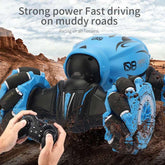 Blue and black remote control car with rugged wheels driving through muddy terrain