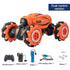 Orange and black remote control stunt car with large wheels, includes controller, watch remote, battery, USB cable, and manual.