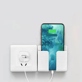 White wall-mounted plastic phone holder with smartphone charging via wall socket