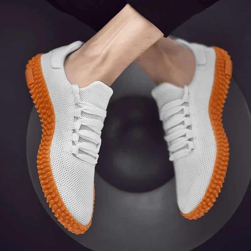 White mesh sneakers with textured orange soles, modern slim fit footwear