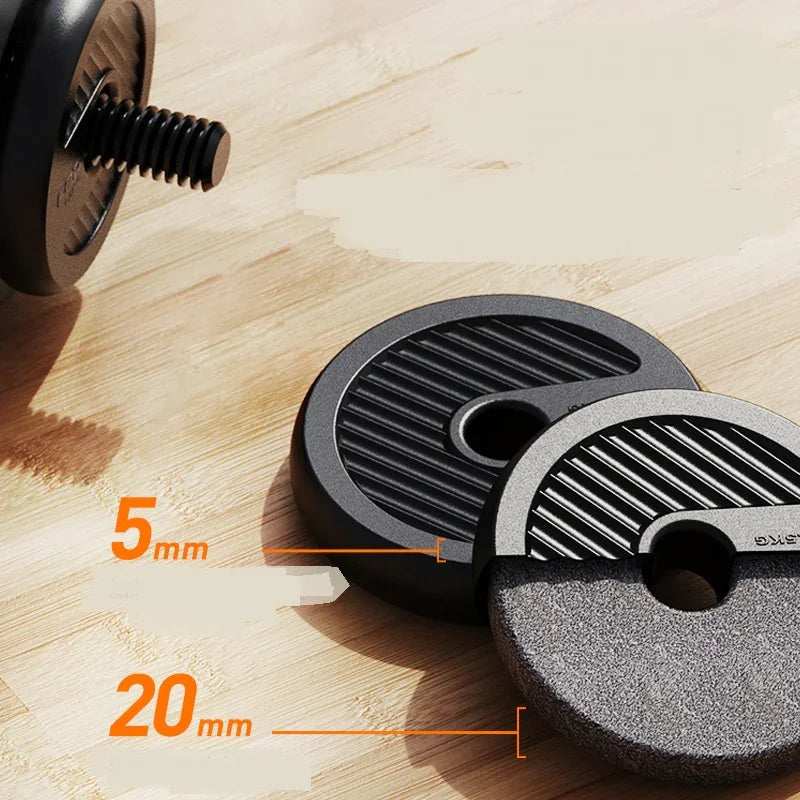 Close-up of two round black ribbed weight plates, 5mm and 20mm thick, on wood surface.