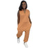 Woman in sleeveless orange jumpsuit with relaxed fit and side pockets, wearing white sneakers