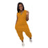 Woman wearing a loose fit, sleeveless mustard yellow jumpsuit with side pockets