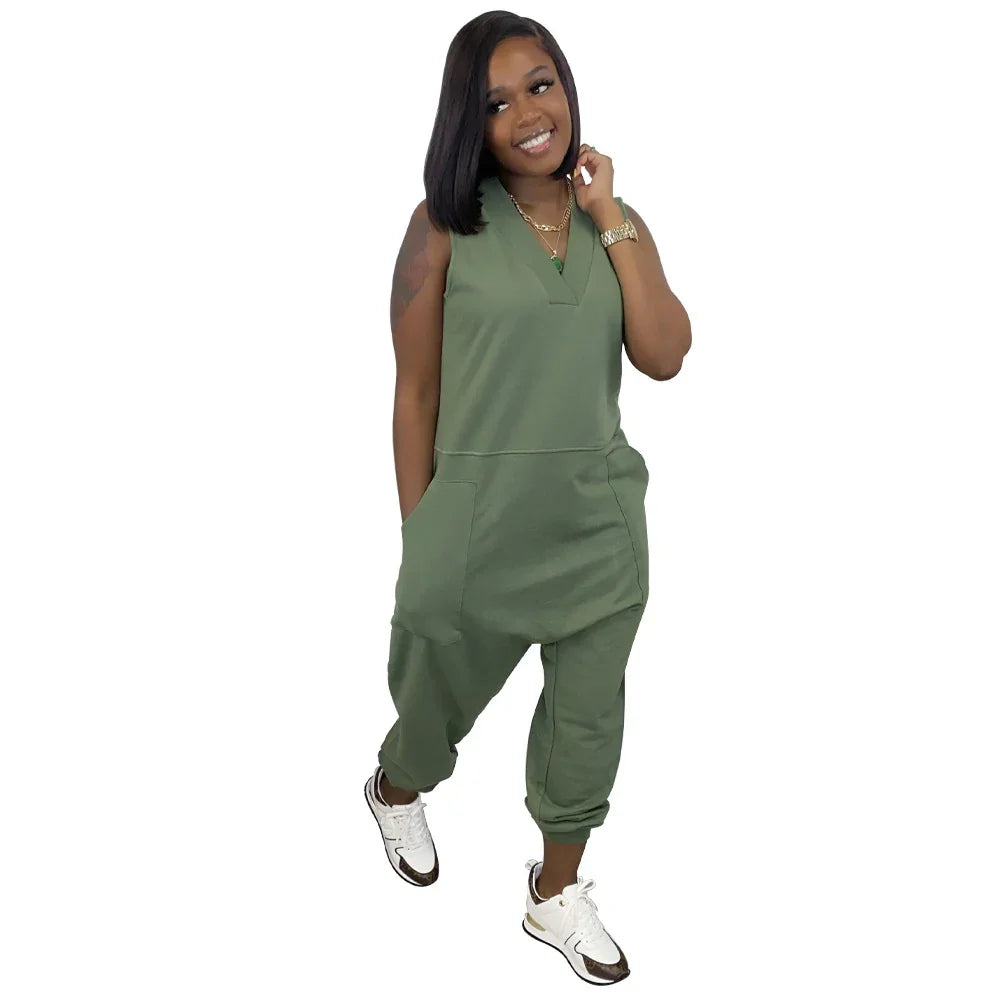 Woman wearing sleeveless green jumpsuit with relaxed fit and side pockets, paired with sneakers