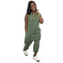 Woman wearing sleeveless green jumpsuit with relaxed fit and side pockets, paired with sneakers