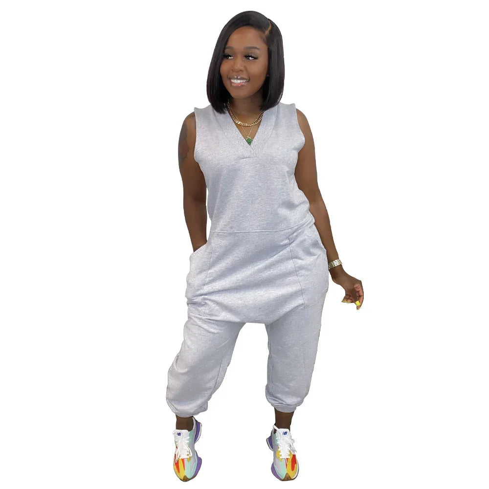 Woman wearing sleeveless gray jumpsuit with relaxed fit and cropped jogger-style legs