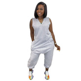 Woman wearing sleeveless gray jumpsuit with relaxed fit and cropped jogger-style legs