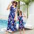Matching blue and white sleeveless leaf print summer dresses, relaxed fit, worn by woman and girl outdoors