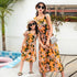 Mother and daughter in matching sleeveless orange floral dresses, relaxed fit, by poolside.