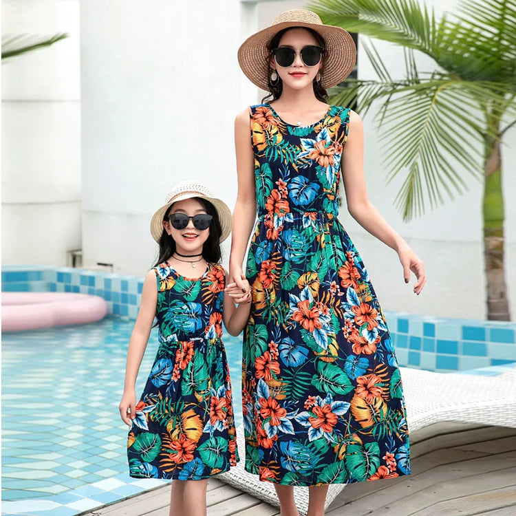 Matching sleeveless floral maxi dresses in vibrant tropical print, lightweight, relaxed fit