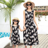 Mother and daughter wearing matching sleeveless black floral print summer dresses with relaxed fit