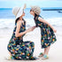 Mother and daughter on beach wearing matching sleeveless floral print maxi dresses