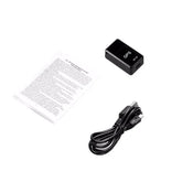 Compact black GPS tracker with USB charging cable and instruction manual on white background