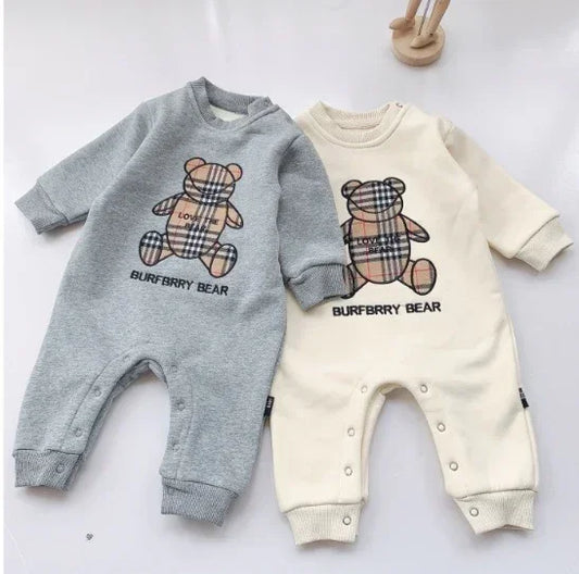 Two long-sleeve baby jumpsuits in grey and cream, with plaid teddy bear prints and snap buttons.