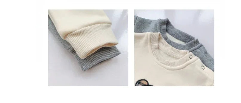 Close-up of cream and gray cotton sweatshirts with ribbed cuffs and snap-button collar