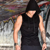 Man wearing black sleeveless hooded streetwear top with drawstrings, slim fit