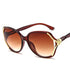Oversized cat-eye sunglasses with brown gradient lenses, gold accents, and glossy plastic frame