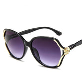 Black oversized sunglasses with gold accents and purple gradient lenses