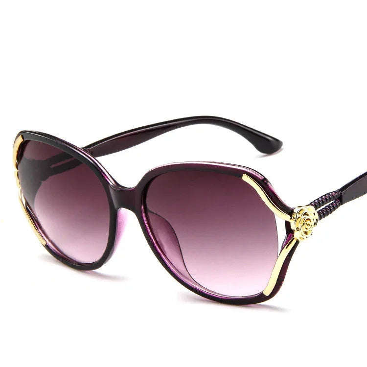 Oversized purple gradient sunglasses with gold accents and decorative floral detail