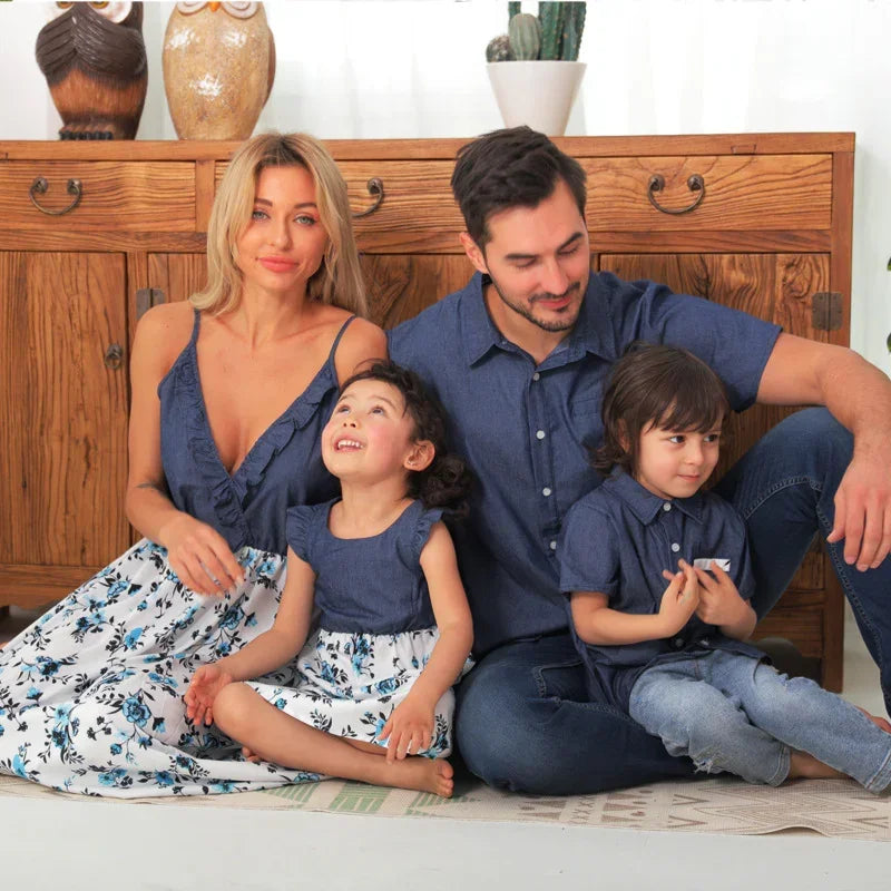 Family wearing matching blue denim tops and blue floral print dresses, casual fit, indoor setting