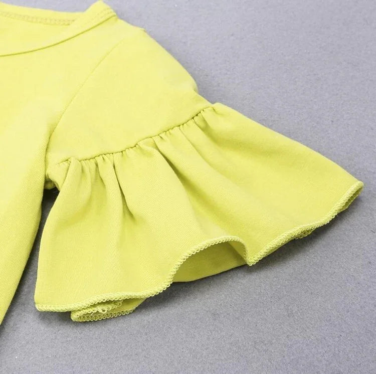Lime green ruffled sleeve top in soft cotton, relaxed fit, minimalist style on gray background.