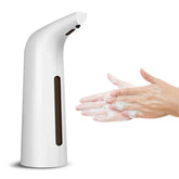 Automatic white soap dispenser dispensing foam onto hands being washed