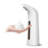 White touchless automatic soap dispenser with foaming soap on a hand
