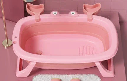 Pink plastic bathtub with playful crab-shaped handles, placed in a modern bathroom setting.