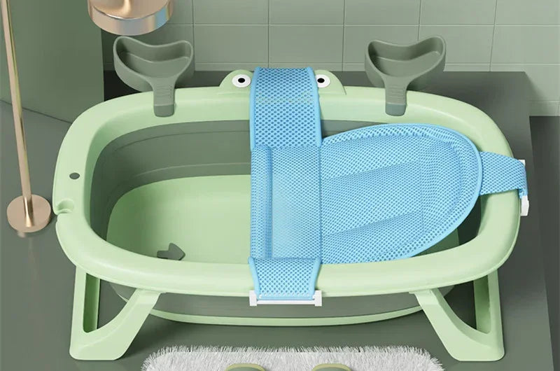 Light green plastic baby bathtub with blue mesh bath seat insert in modern bathroom